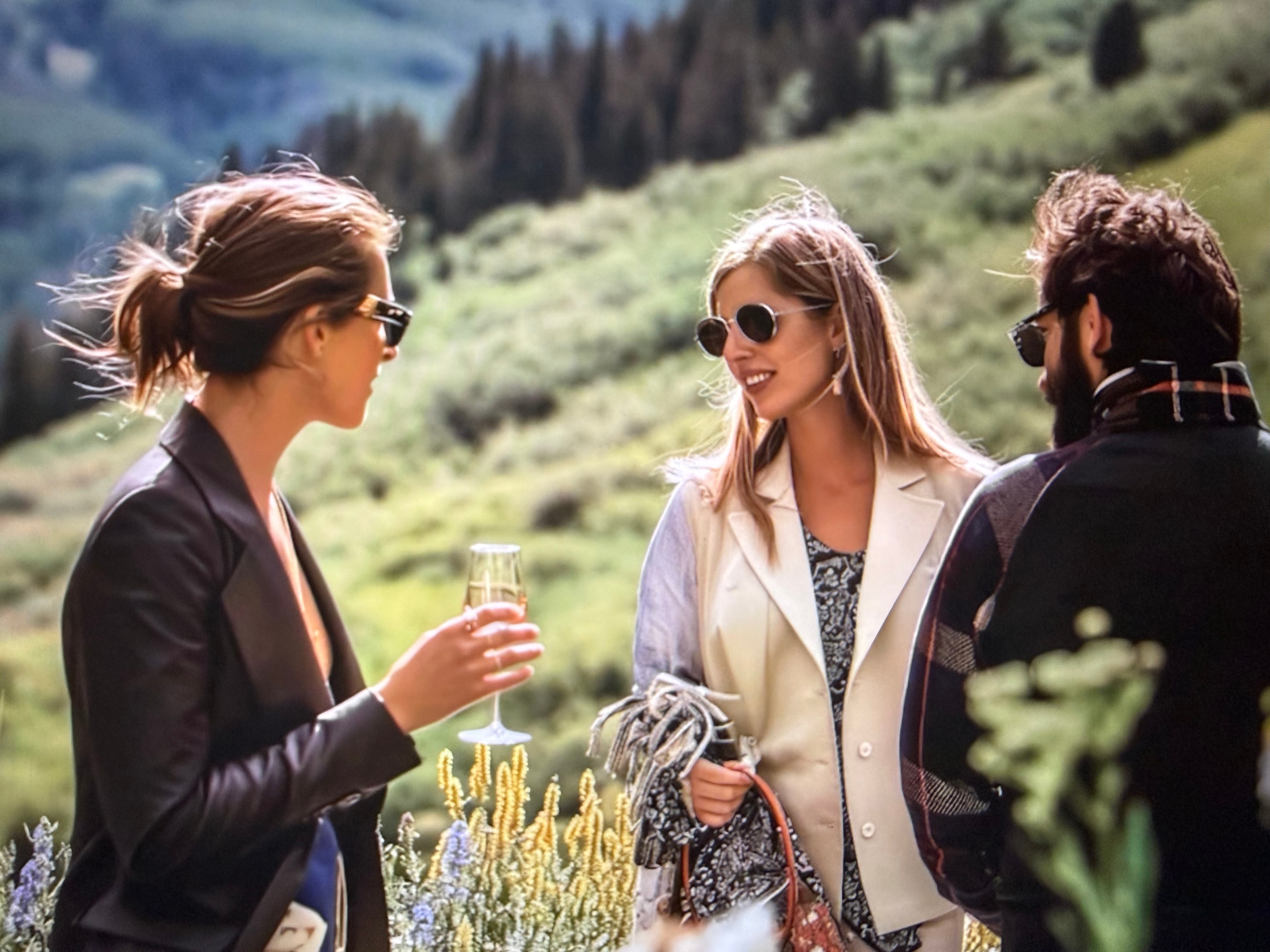 Friends gathered outdoors with drinks in an Aspen mountain setting